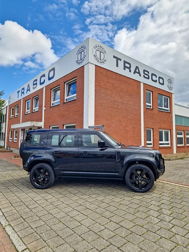 Defender 110 V8 з TRASCO A-KIP® Level 6 перед будівлею TRASCO в Бремені