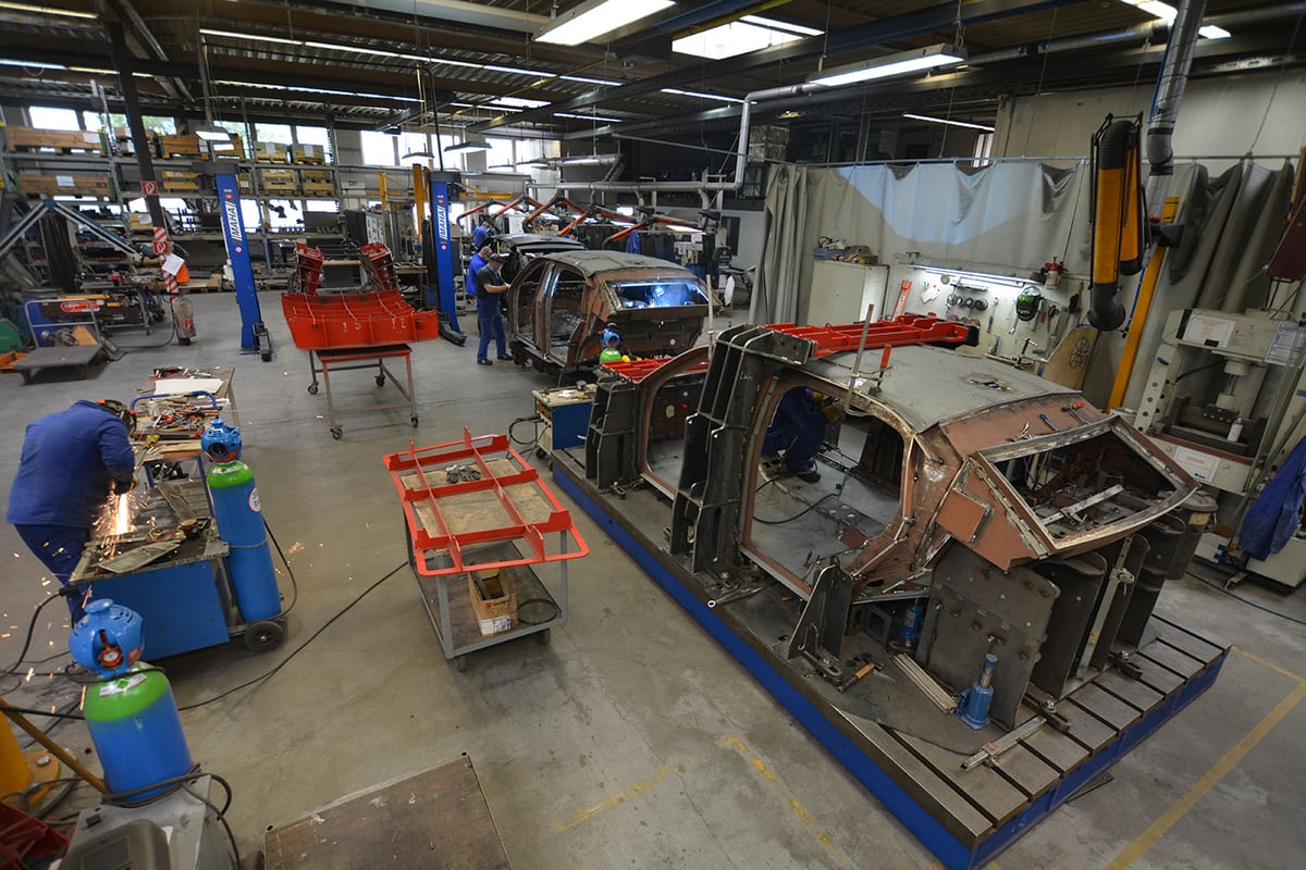 Vehicle bodies in fixtures during armoring at TRASCO