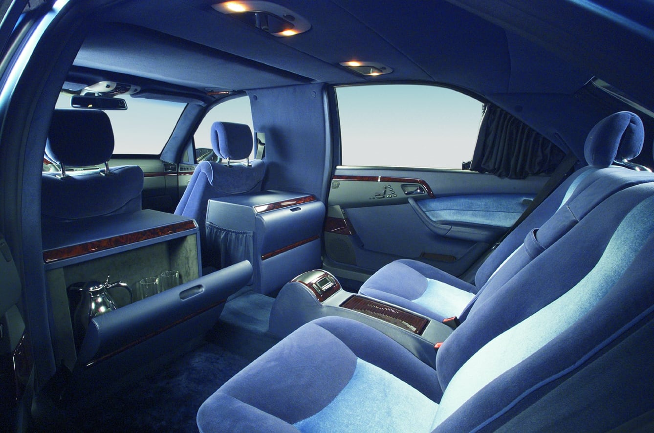 Rear compartment in blue velour with partition wall and bar in an extended limousine