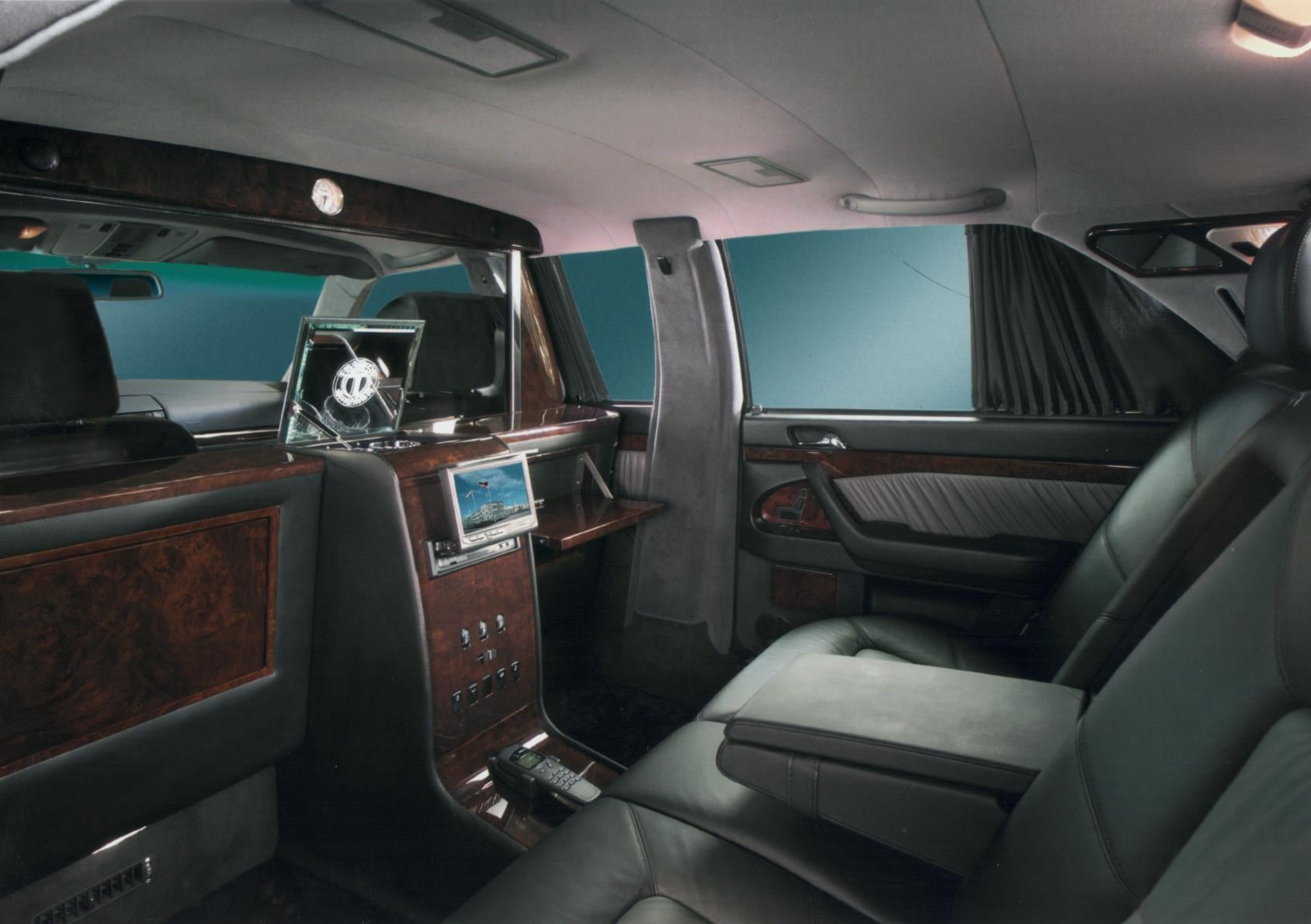 Partition wall with display, controls and storage compartments in a limousine