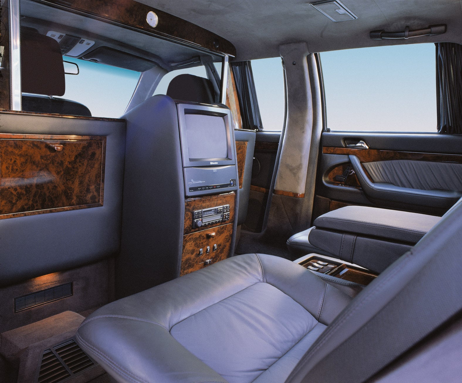 Trennwand mit Monitor und Schrankelement mit Holzfurnier, vom Fondsitz einer verlängerten Limousine aus gesehen