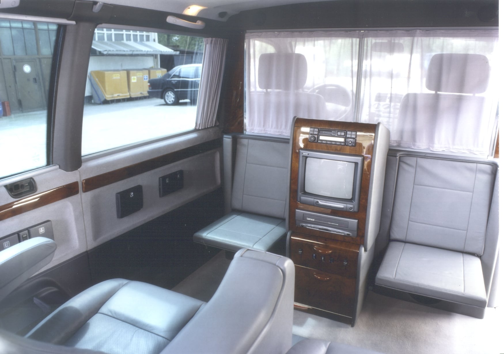 Extended limousine with facing seats and a central console with monitor