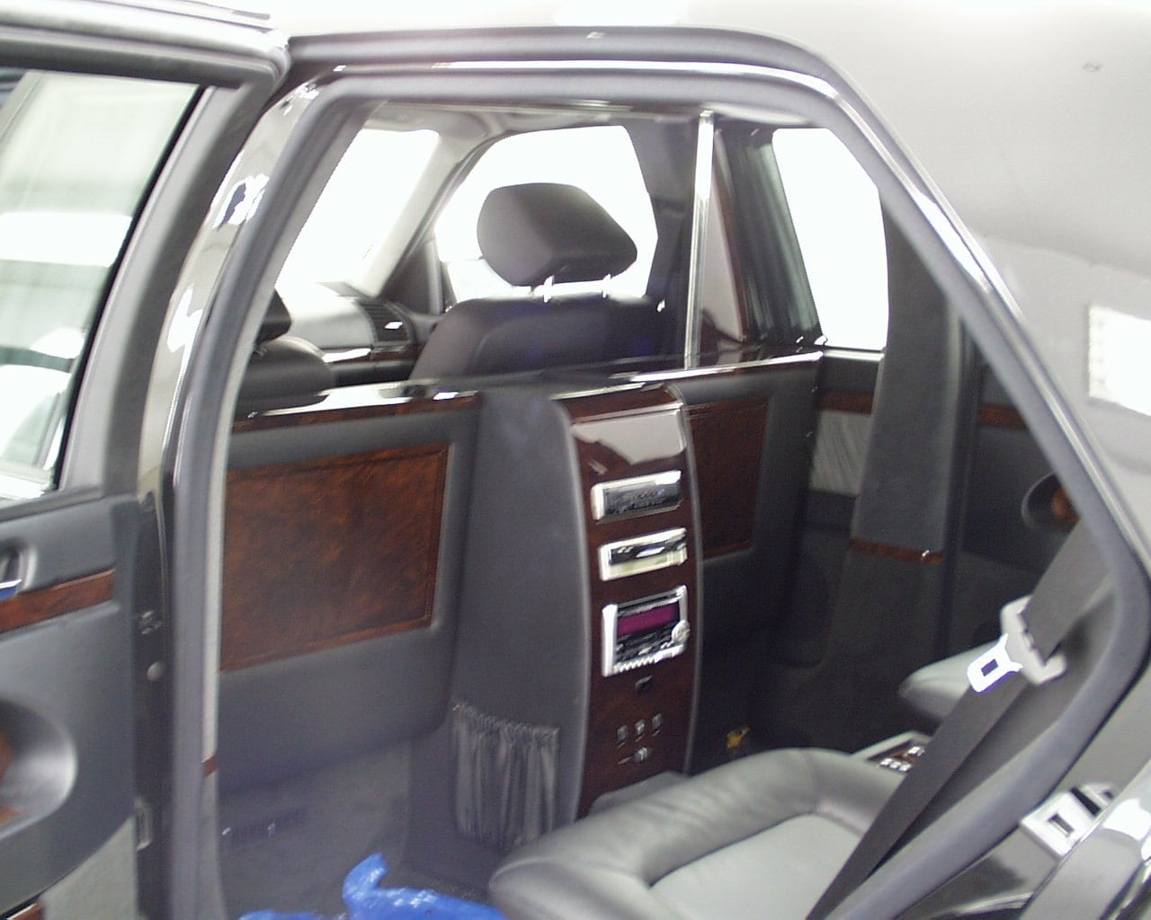 Trennwandkonsole mit Audiokomponenten und Holzfurnier in einer Limousine