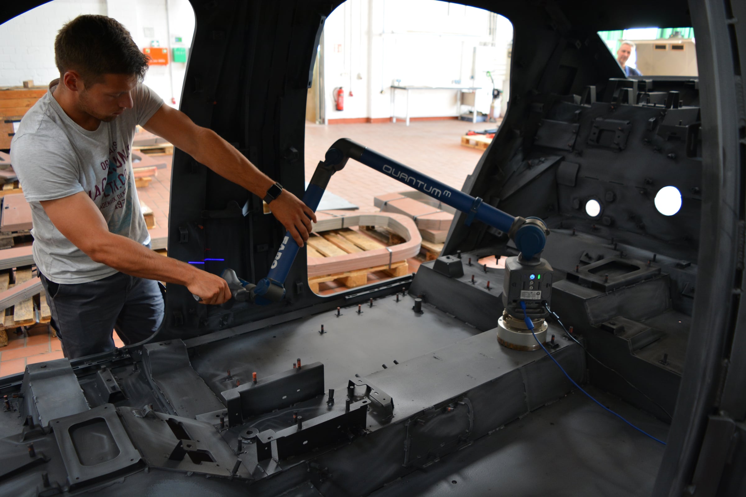 Ingenieur digitalisiert einen Fahrzeuginnenraum mit einem mobilen 3D-Messarm