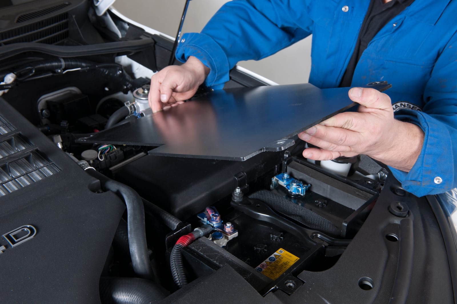 Montage der Batteriepanzerung im Motorraum eines gepanzerten SUVs