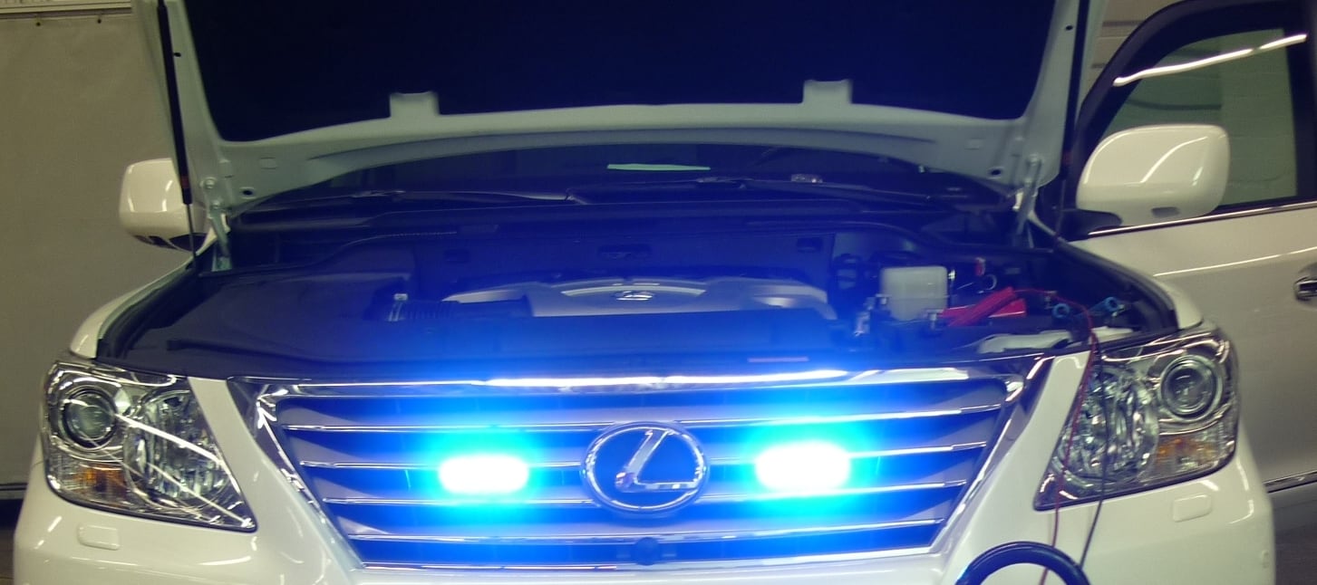 Blaue Blitzleuchten hinter dem Kühlergrill eines gepanzerten Lexus-SUVs