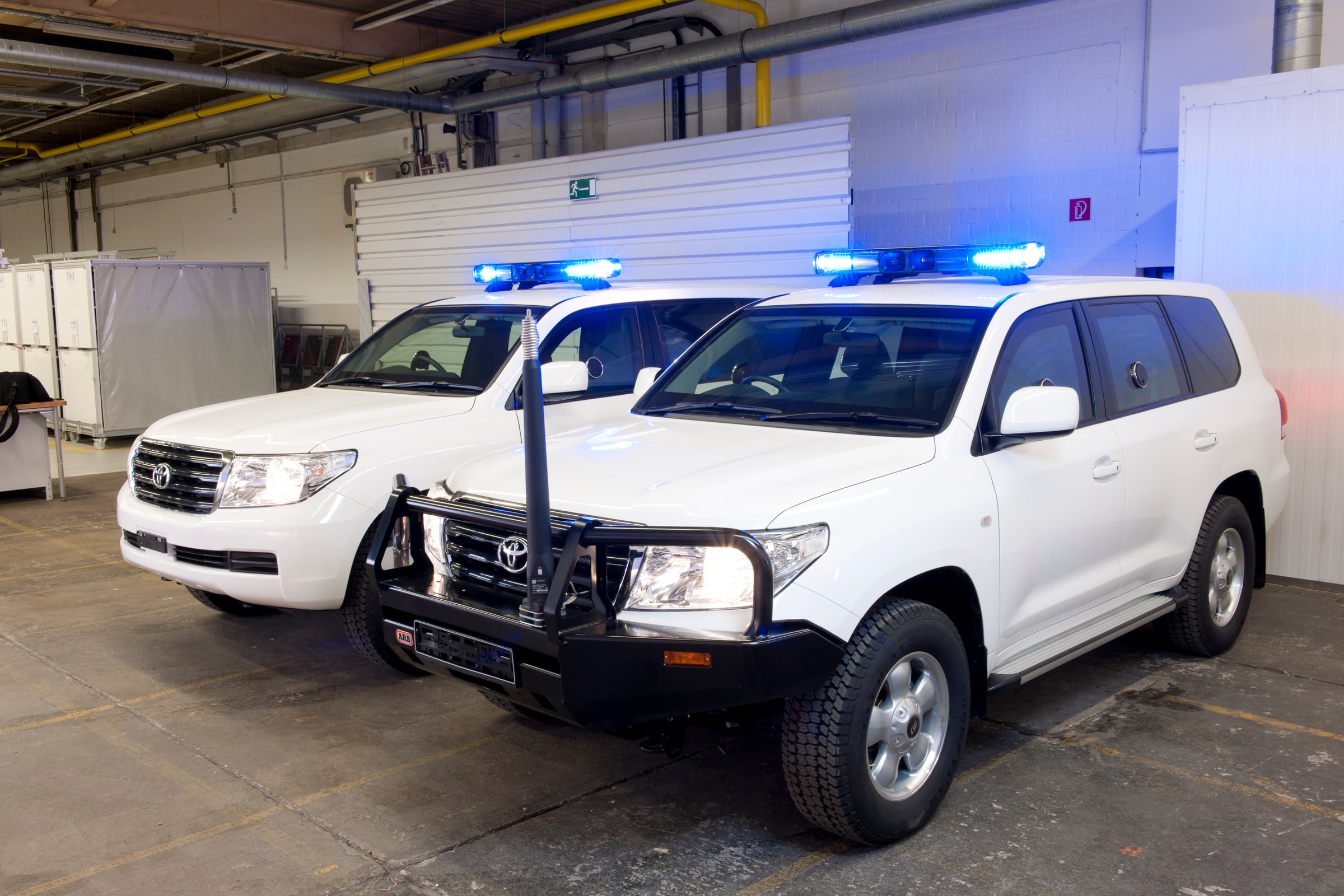 Zwei gepanzerte Toyota Land Cruiser mit Lichtbalken auf dem Dach im TRASCO-Werk